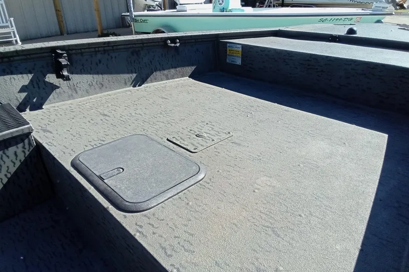 Slide: The Image of 2020 War Eagle 750 Gladiator boat interior with storage compartment, textured flooring, and seating area. - 8