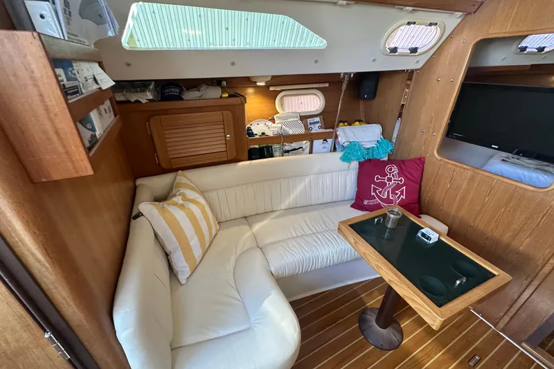 Slide: The Image of Cozy interior of a 2005 Catalina 310 sailboat with white seating and wooden accents. - 13