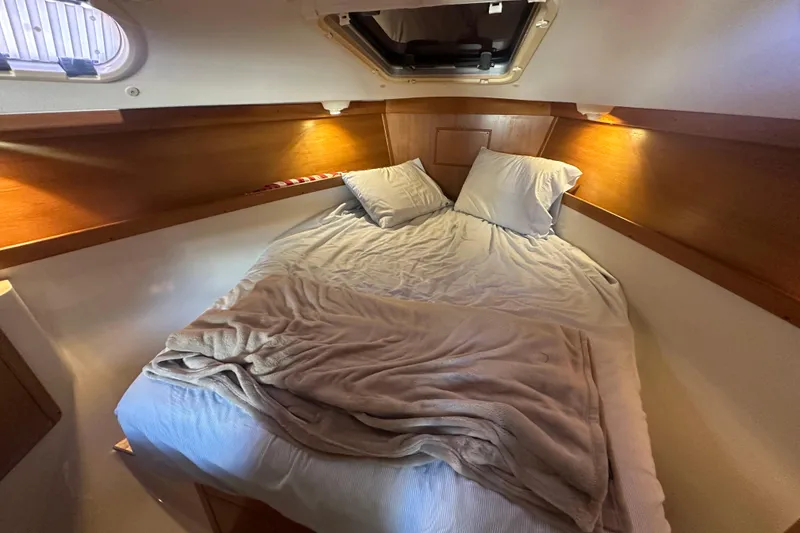 Slide: The Image of Cozy cabin interior of 2005 Catalina 310 sailboat with bed and wooden accents. - 19