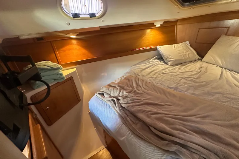 Slide: The Image of Cozy cabin interior of a 2005 Catalina 310 sailboat with bed and wooden accents. - 20