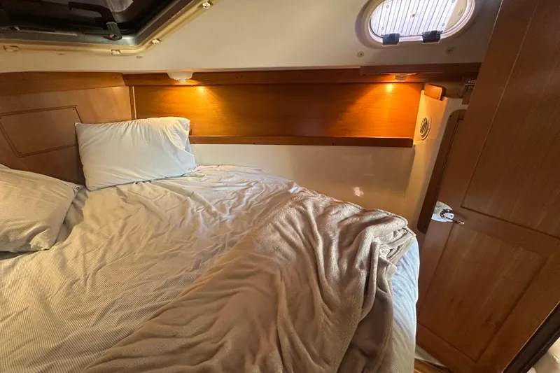 Slide: The Image of Cozy cabin interior of a 2005 Catalina 310 sailboat with bed and warm lighting. - 21