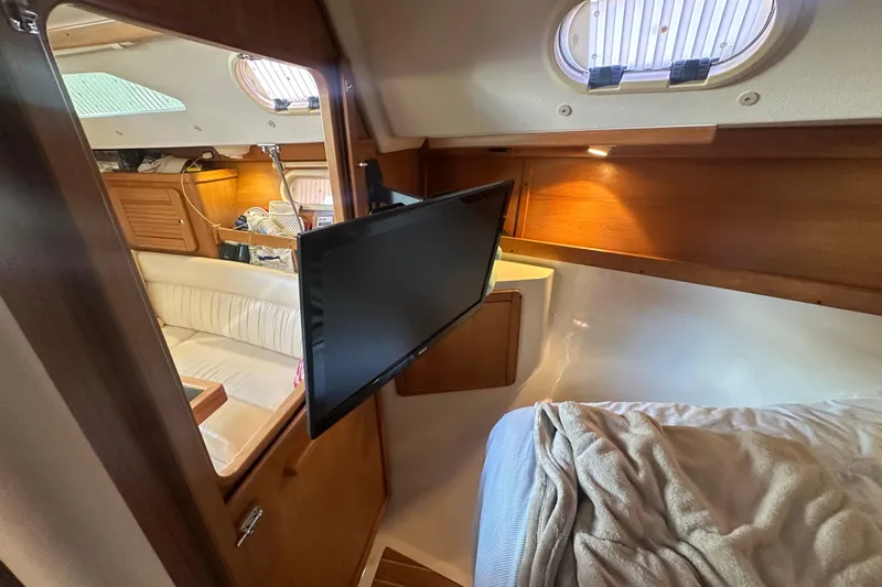 Slide: The Image of Interior of a 2005 Catalina 310 yacht with cozy seating and mounted TV. - 22