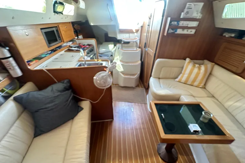 Slide: The Image of Interior of a 2005 Catalina 310 sailboat with cozy seating and wooden finishes. - 23