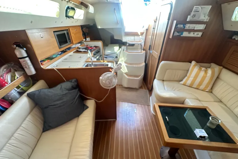 Slide: The Image of Interior of a 2005 Catalina 310 sailboat with cozy seating and wooden finishes. - 24