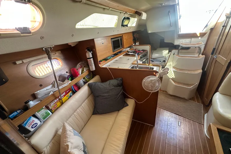 Slide: The Image of Interior of a 2005 Catalina 310 sailboat with cozy seating and compact kitchen area. - 26