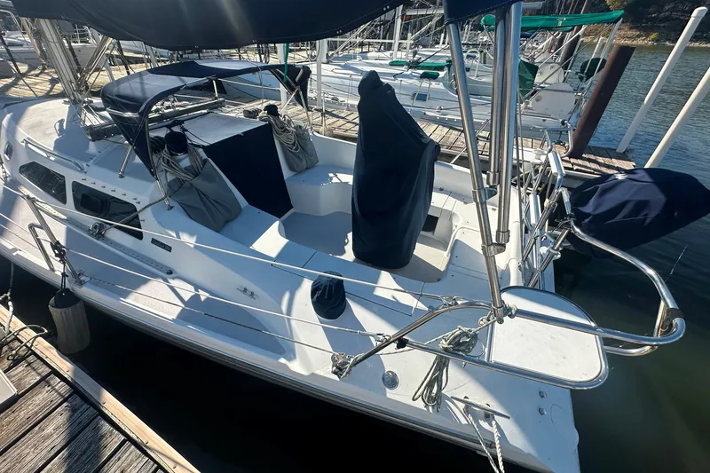 Slide: The Image of 2005 Catalina 310 sailboat docked, featuring covered cockpit and sleek design. - 3