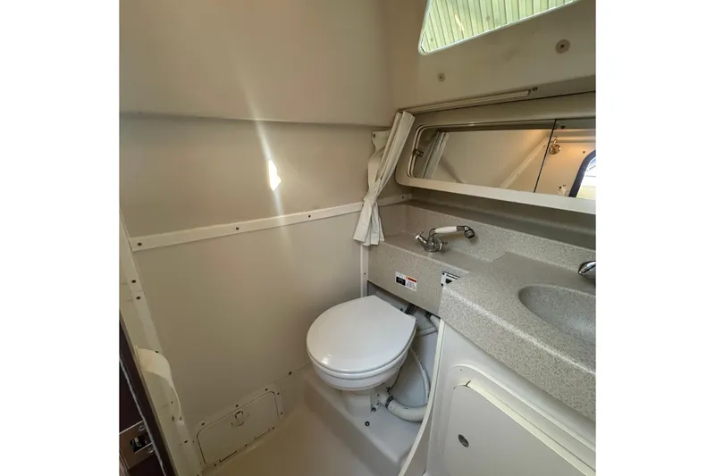 Slide: The Image of 2005 Catalina 310 boat bathroom with toilet, sink, and mirror. - 32