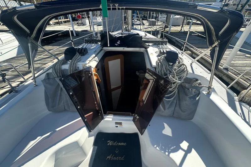 Slide: The Image of Catalina 310 sailboat cockpit with open cabin door, ropes, and welcome mat, 2005 model. - 8