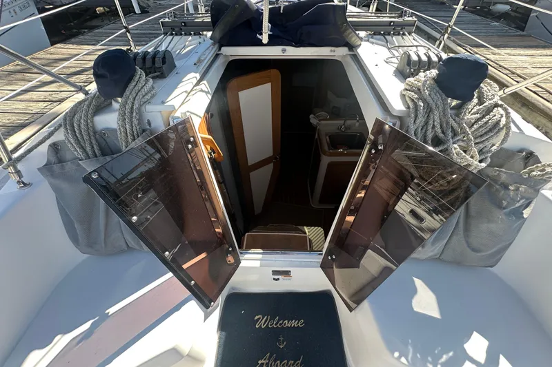 Slide: The Image of Catalina 310 sailboat cockpit entrance with open doors, ropes, and "Welcome Aboard" mat. - 9