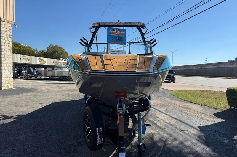 Slide: The Image of 2026 Moomba Mojo boat on trailer, displayed outdoors at dealership. - 2
