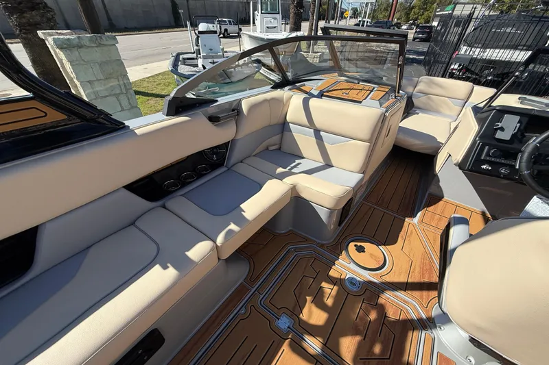Slide: The Image of 2026 Moomba Mojo boat interior with beige seating and wood-patterned flooring. - 25