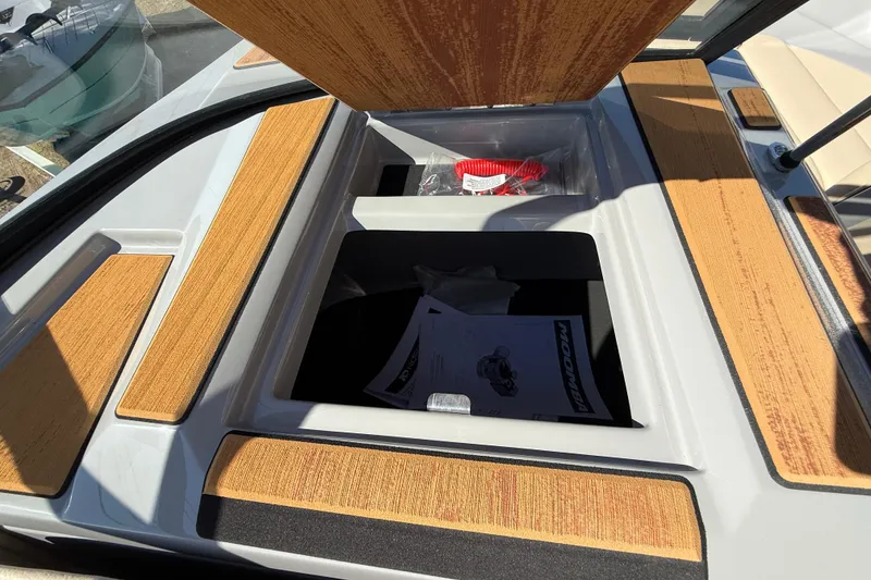 Slide: The Image of 2026 Moomba Mojo boat storage compartment with open lid and wooden accents. - 40