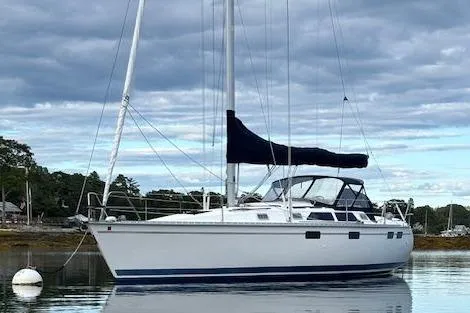 The Image of 1996 Hunter 37.5 Legend sailboat anchored on calm water with cloudy sky. - 0