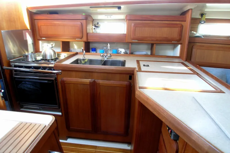 Slide: The Image of Interior of 1996 Hunter 37.5 Legend yacht kitchen with wooden cabinetry and modern appliances. - 4