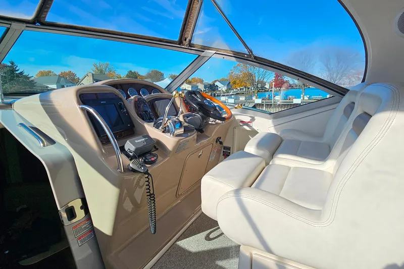 Slide: The Image of 2004 Sea Ray 320 Sundancer helm with steering wheel, controls, and gauges. - 11