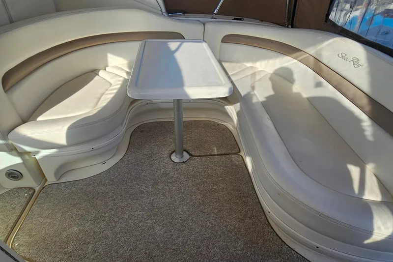Slide: The Image of Interior of 2004 Sea Ray 320 Sundancer with white seating and table, marina view. - 5