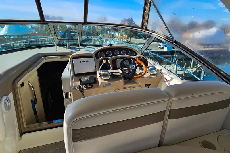 Slide: The Image of Interior view of 2004 Sea Ray 320 Sundancer boat cockpit with steering wheel and controls. - 7