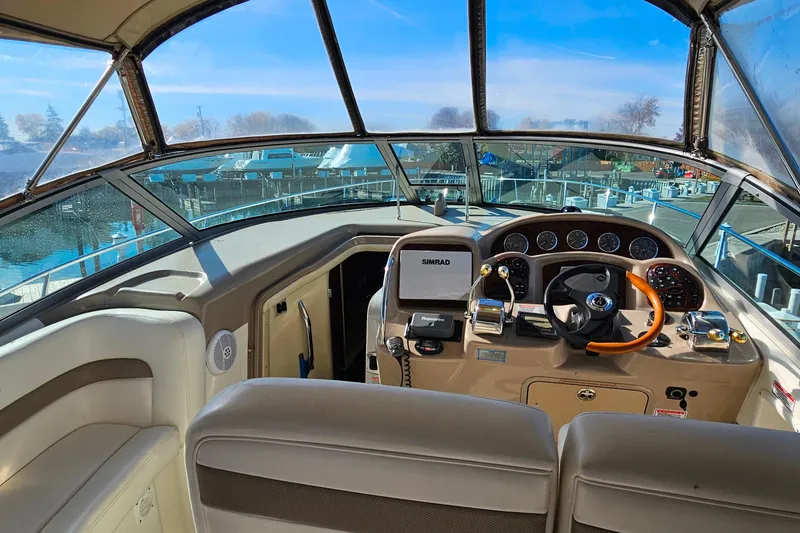 Slide: The Image of 2004 Sea Ray 320 Sundancer cockpit with steering wheel, gauges, and navigation equipment. - 8