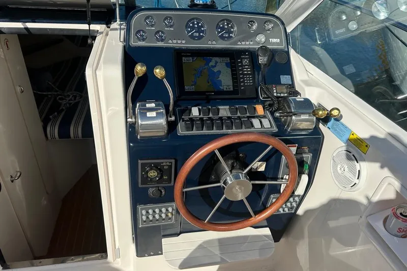 Slide: The Image of 2002 Tiara Yachts 2900 Coronet helm with navigation controls and wooden steering wheel. - 10