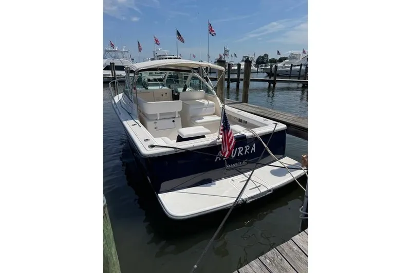 Slide: The Image of 2002 Tiara Yachts 2900 Coronet docked, featuring American flag and spacious deck. - 2