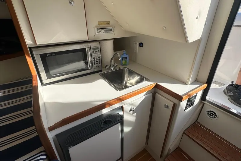 Slide: The Image of Compact kitchen area in a 2002 Tiara Yachts 2900 Coronet with microwave and sink. - 22