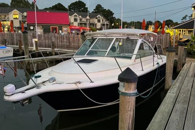 Slide: The Image of 2002 Tiara Yachts 2900 Coronet docked at a marina, surrounded by waterfront buildings. - 3