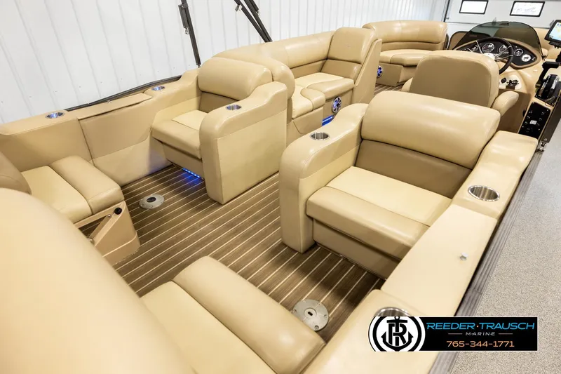 Slide: The Image of Luxurious interior of 2017 Manitou Oasis SHP pontoon boat with beige seating and wood flooring. - 12