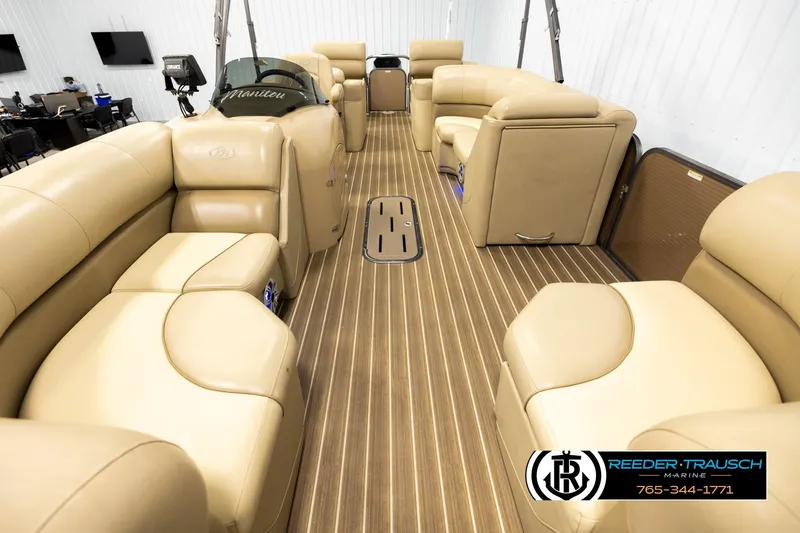 Slide: The Image of 2017 Manitou Oasis SHP pontoon boat interior with tan seating and wood-style flooring. - 13