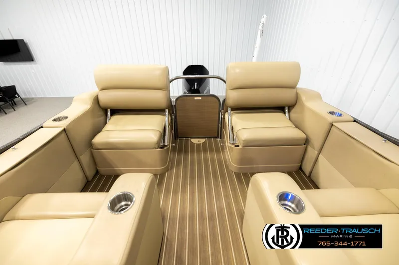 Slide: The Image of 2017 Manitou Oasis SHP boat interior with beige seating and wood-style flooring. - 15