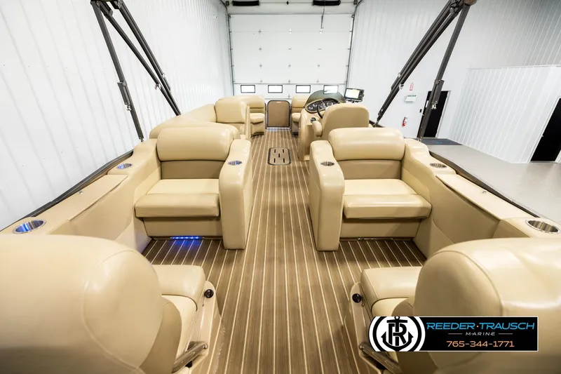 Slide: The Image of 2017 Manitou Oasis SHP pontoon boat interior with beige seating and wood-style flooring. - 16