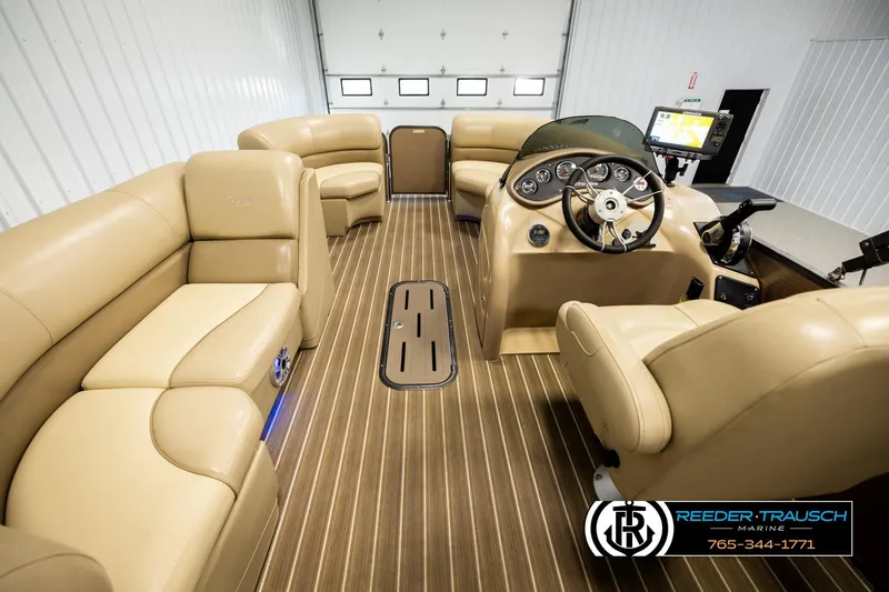 Slide: The Image of 2017 Manitou Oasis SHP pontoon boat interior with beige seating and modern dashboard. - 17