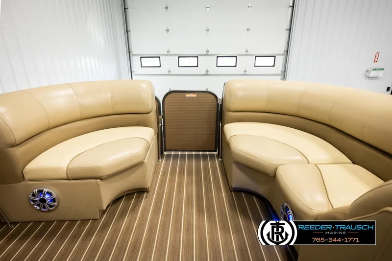 Slide: The Image of 2017 Manitou Oasis SHP pontoon boat interior with tan seating and wood-style flooring. - 18