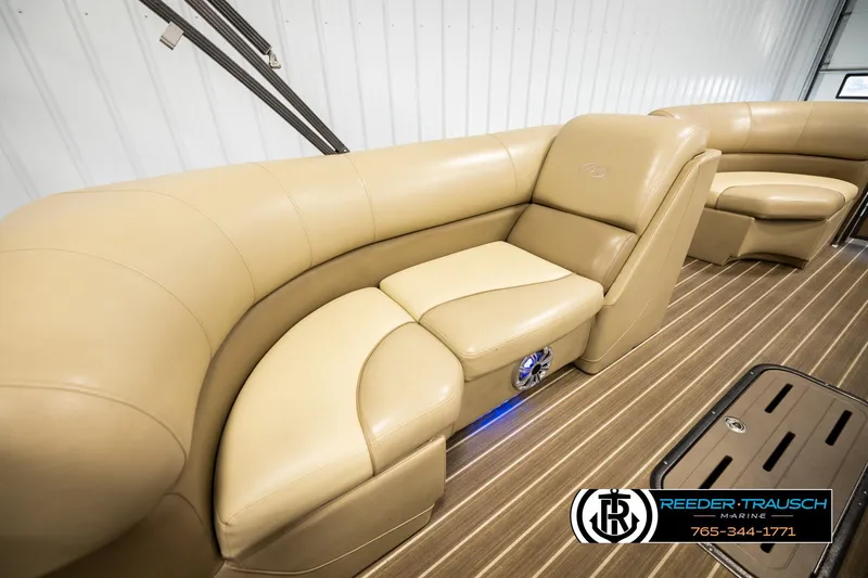 Slide: The Image of 2017 Manitou Oasis SHP boat interior with tan leather seating and wood flooring. - 20