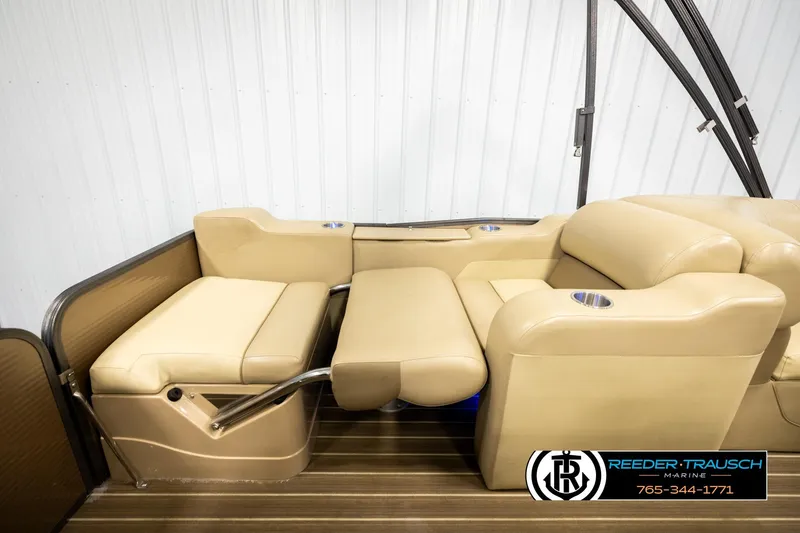 Slide: The Image of 2017 Manitou Oasis SHP pontoon boat interior with beige seating and cup holders. - 24