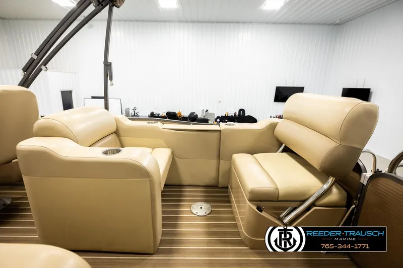 Slide: The Image of 2017 Manitou Oasis SHP boat interior with beige seating and wood flooring. - 27