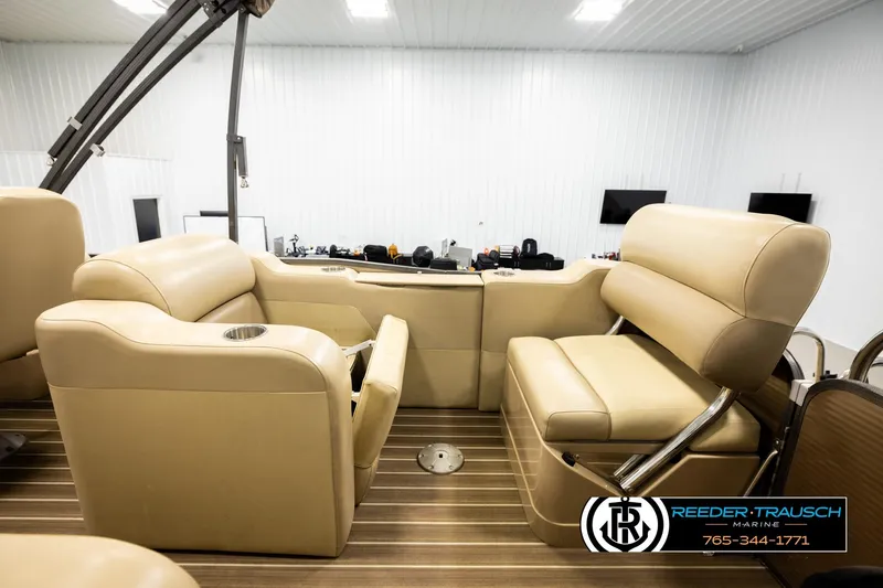 Slide: The Image of 2017 Manitou Oasis SHP boat interior with beige seating and wood flooring. - 28