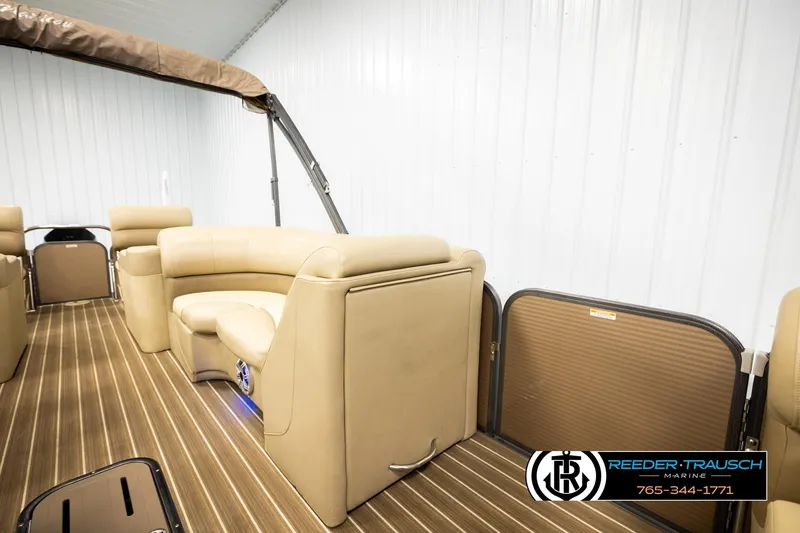 Slide: The Image of 2017 Manitou Oasis SHP pontoon boat interior with tan seating and wood-style flooring. - 31