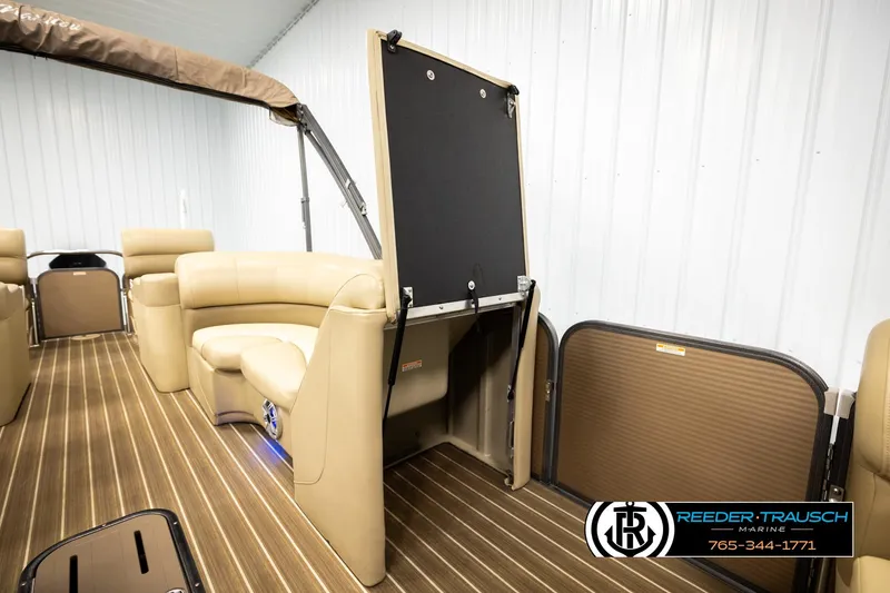Slide: The Image of 2017 Manitou Oasis SHP pontoon boat interior with tan seating and wood-style flooring. - 32
