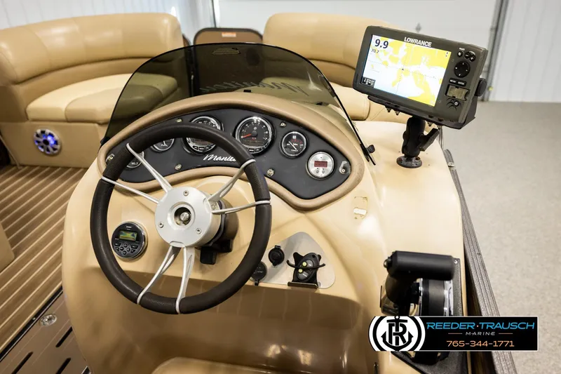 Slide: The Image of 2017 Manitou Oasis SHP boat dashboard with steering wheel and navigation system. - 33