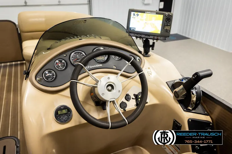 Slide: The Image of 2017 Manitou Oasis SHP boat dashboard with steering wheel and navigation system. - 34