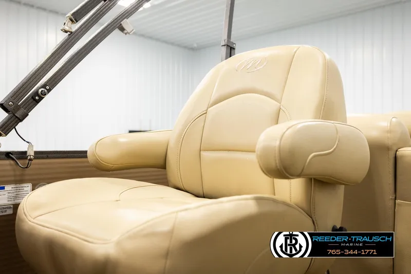Slide: The Image of Luxurious beige captain's chair on 2017 Manitou Oasis SHP boat, featuring armrests and logo. - 44