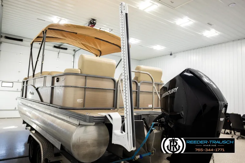 Slide: The Image of 2017 Manitou Oasis SHP pontoon boat with Mercury engine in indoor storage. - 53