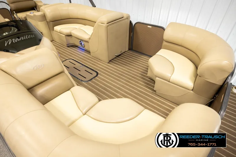 Slide: The Image of 2017 Manitou Oasis SHP pontoon boat interior with beige seating and wood-style flooring. - 9