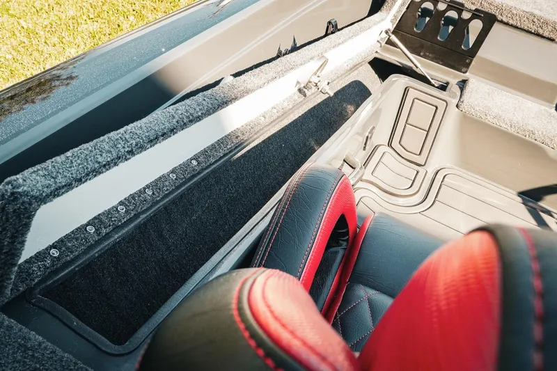 Slide: The Image of Interior view of 2026 Phoenix 721 ZXL boat, featuring red and black seating and storage compartments. - 16