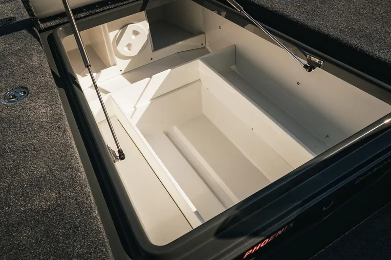 Slide: The Image of Open storage compartment in 2026 Phoenix 721 ZXL boat, featuring carpeted edges and hydraulic supports. - 22