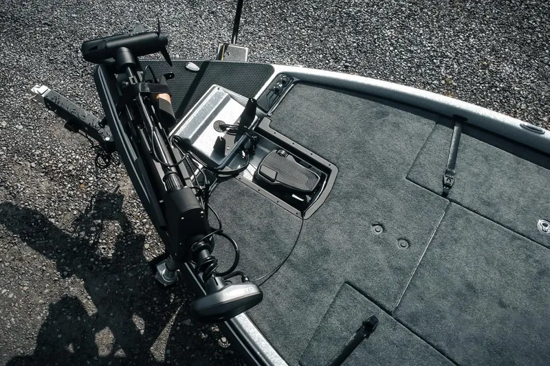 Slide: The Image of 2026 Phoenix 721 ZXL boat deck with trolling motor and foot pedal on gravel surface. - 5