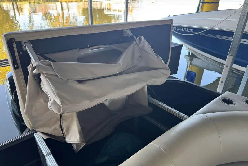 Slide: The Image of 2015 Crest 22 Crest I boat with open storage compartment and beige cover. - 13