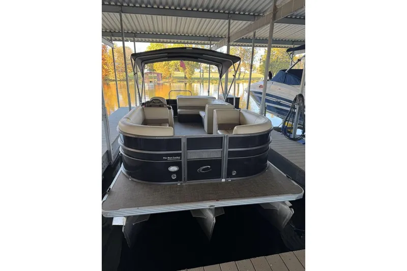 Slide: The Image of 2015 Crest 22 Crest I pontoon boat docked under a covered marina. - 2