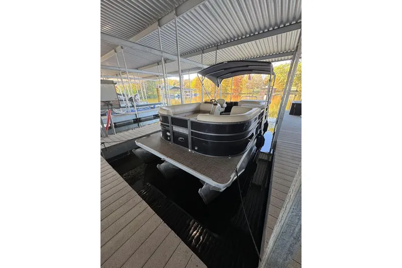 Slide: The Image of 2015 Crest 22 Crest I pontoon boat docked under a covered marina. - 3