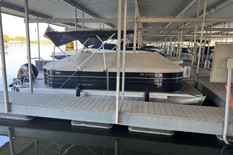 Slide: The Image of 2015 Crest 22 Crest I pontoon boat docked under a covered marina. - 32
